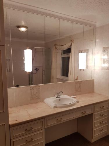 a bathroom with a sink and a large mirror at Glenkerry in Ingoldmells