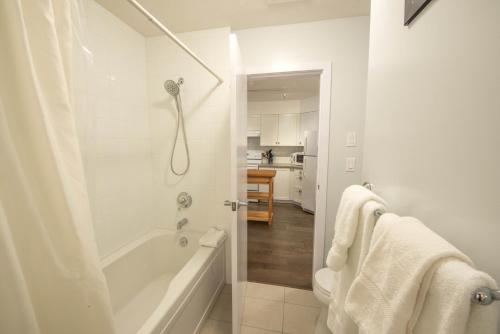 a white bathroom with a tub and a shower at Luxury Oceanfront Condo by OnlyBC 101 in Tofino