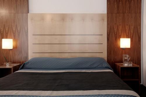 a bedroom with a bed with two lamps on two tables at Hotel Grand'Italia in Padova