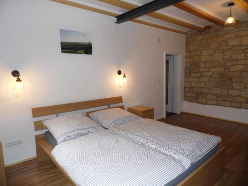 una camera con un grande letto in un muro di mattoni di Winzerhaus Frankweiler a Frankweiler