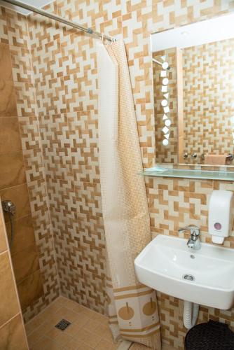 a bathroom with a sink and a shower with a mirror at Motel Orhideja in Donji Vakuf