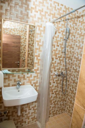 a bathroom with a sink and a shower with a mirror at Motel Orhideja in Donji Vakuf