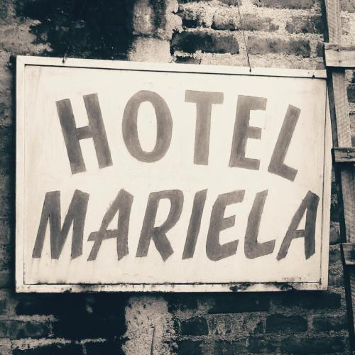 a sign on a brick wall with the words hotel mariah at Hostal Mariella in Estelí