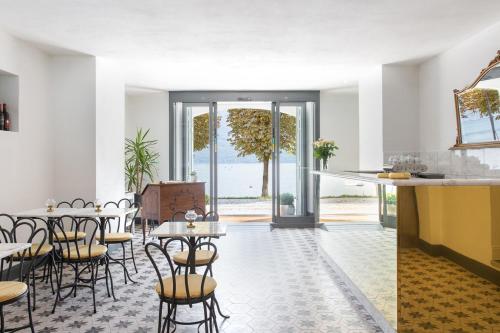 cocina y comedor con mesas y sillas en Villa Maria Apartments, en Cannobio