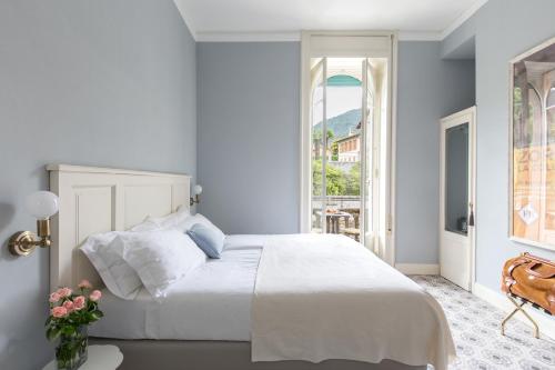 a bedroom with a white bed and a window at Villa Maria Boutique Hotel in Cannobio