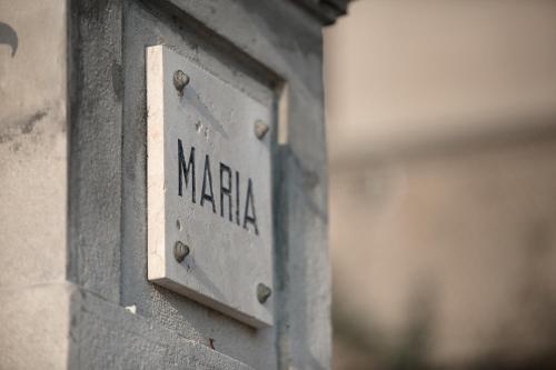 a metal sign on the side of a building at Villa Maria Boutique Hotel in Cannobio
