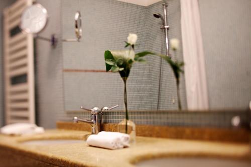 a flower in a vase on a bathroom sink at Hotel Grand'Italia in Padova