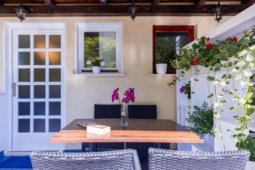 een tafel en stoelen met bloemen op een patio bij Niki Apartment in Dubrovnik