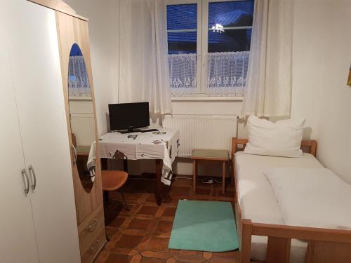 Kleines Zimmer mit einem Bett und einem Schreibtisch mit einem Computer. in der Unterkunft Eisenerzer Hof in Eisenerz