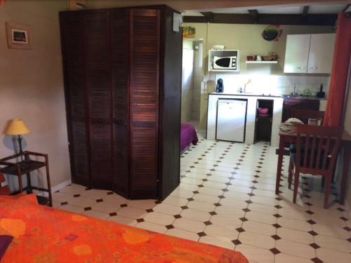 a kitchen with a table and a kitchen with a refrigerator at Le bungalow des bougainvilliers in Ducos