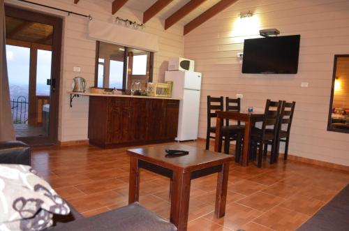 a living room with a refrigerator and a table with chairs at Besof Haderech in Misgav ‘Am