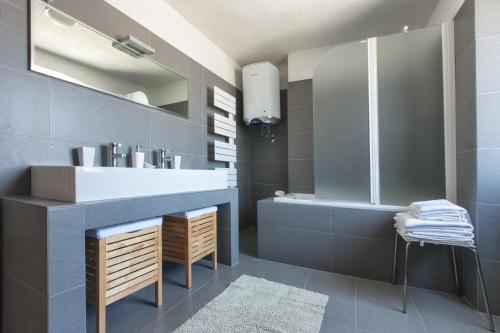 een badkamer met een wastafel, een bad en een spiegel bij Casa Bumbara in Vodnjan