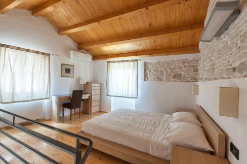 een slaapkamer met een bed en een bureau bij Casa Bumbara in Vodnjan