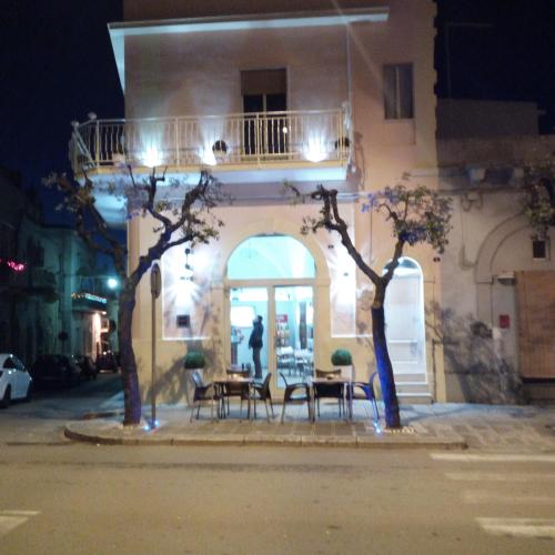 a table and chairs in front of a building at night at B&B miccoli in Grottaglie