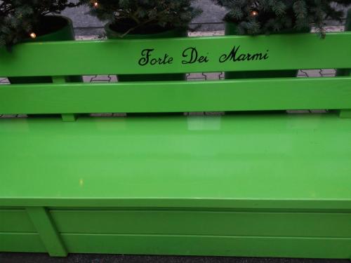 a green bench with the words folk de maurer written on it at sole mare versilia in Cinquale