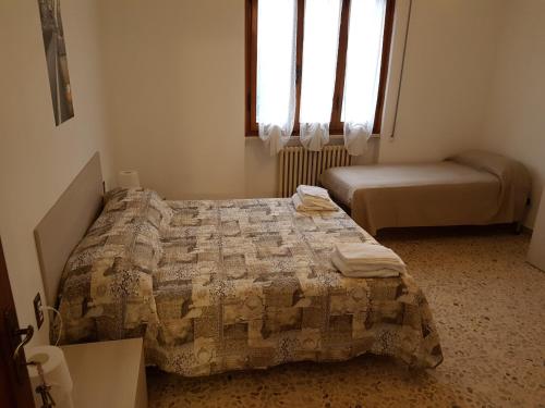 a bedroom with two beds and two windows at B&B Buscemi in Pistoia