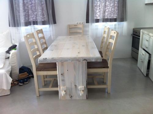 a wooden table and chairs in a kitchen at Plori Studios and Apartments in Aegiali