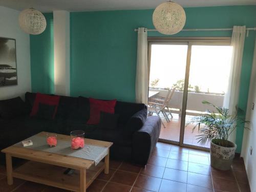 ein Wohnzimmer mit einem Sofa und einem Tisch in der Unterkunft Sailor Home El Medano in El Médano