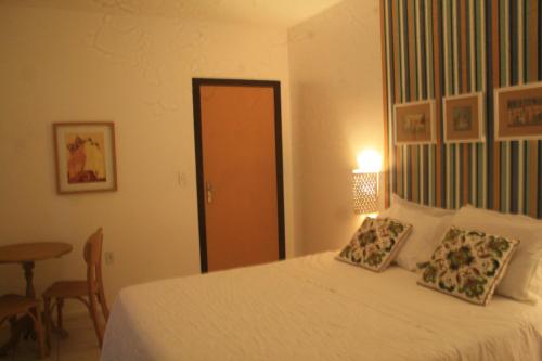 a bedroom with a bed with two pillows on it at Pousada Narinari in Bombinhas