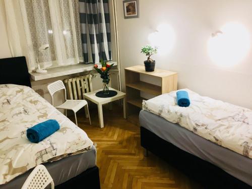 een slaapkamer met 2 bedden en een tafel en een stoel bij Kotlarska Apartment in Wrocław