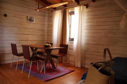 a wooden dining room with a table and chairs at Angelo in Punta Del Diablo