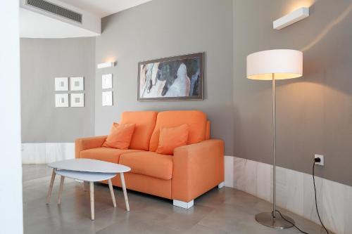 a living room with an orange couch and a table at Hotel Spa Calagrande Cabo de Gata in Las Negras