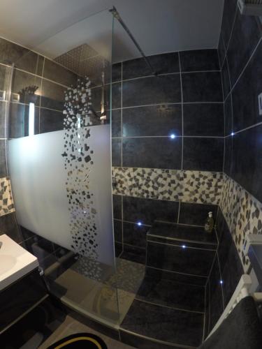 baño con ducha y puerta de cristal en DISNEYLAND-PARIS aux portes de la BATCAVE, en Bussy-Saint-Georges