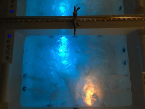 a mirror on a wall with a blue object at Central Business Apartments Jacuzzi in Belgrade
