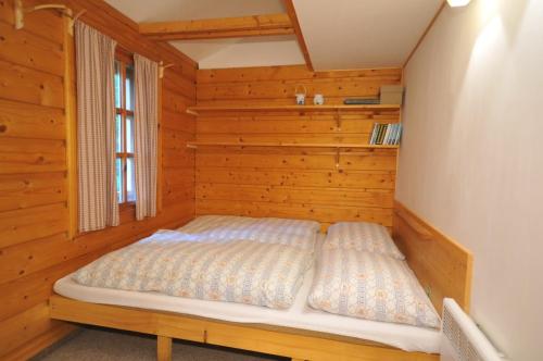 a bedroom with a bed in a wooden room at Chata Krajinka in Ždiar