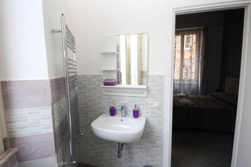 a white bathroom with a sink and a shower at Oasi del Turista in Palermo