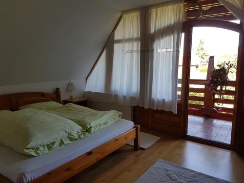 a bedroom with a bed and a sliding glass door at Ginavilla in Keszthely