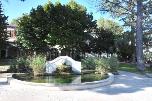 a fountain in a garden in front of a building at Domaine du Grand Malherbes in Aimargues