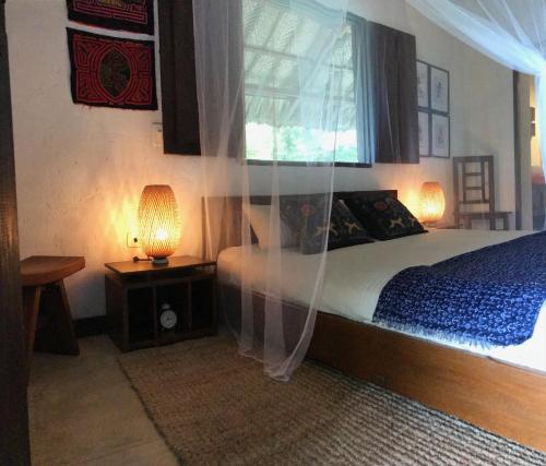 a bedroom with a bed with curtains and a window at Reserva Natural Tierra Adentro in Minca