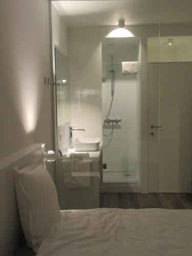 a bathroom with a sink and a shower and a toilet at Hotel Muske Pitter in Mechelen