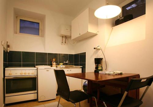 Praga apartment في بوخارست: مطبخ مع طاولة خشبية وطاولة وطاولة
