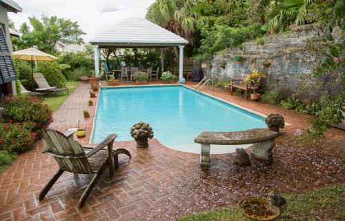 a swimming pool with a bench and a gazebo at Frognal Apartment in North Shore Village