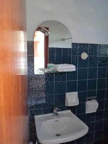 a bathroom with a sink and a mirror at Kokkinos Apartments in Arillas