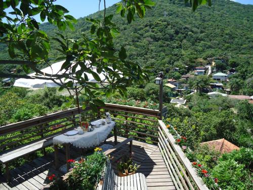 - un balcon avec une table et des fleurs sur une colline dans l'établissement Casa na montanha com vista para o mar, à Florianópolis