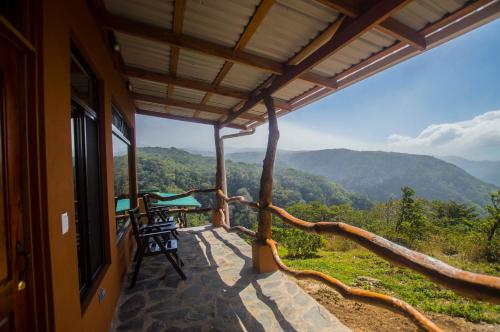 a balcony of a house with a view of the mountains at Rainbow Valley Lodge Costa Rica in Monteverde Costa Rica