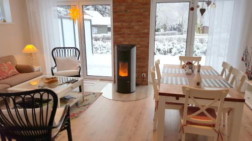 a living room with a fireplace and a table and chairs at Ferienhaus Bergidylle in Winterberg