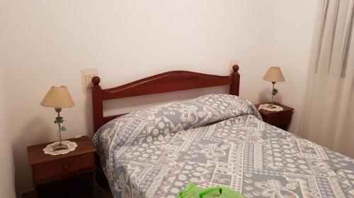 1 dormitorio con 1 cama y 2 mesitas de noche con lámparas en Casa Galicia en San Bernardo