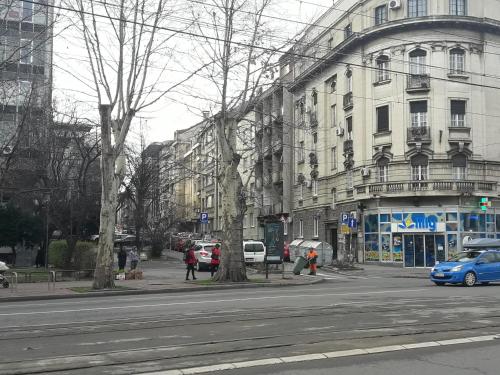 a city street with cars parked in front of buildings at Momo Apartment in Belgrade