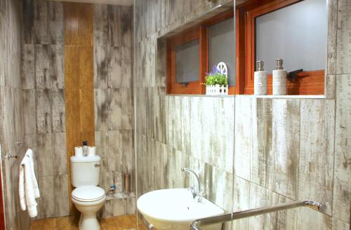 a bathroom with a toilet and a sink at Green Haven Luxury Apartments in Ezulwini