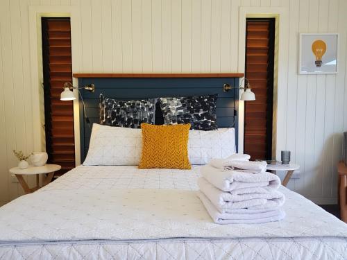 a bedroom with a bed with towels on it at Admiral Waters in Cooks Beach