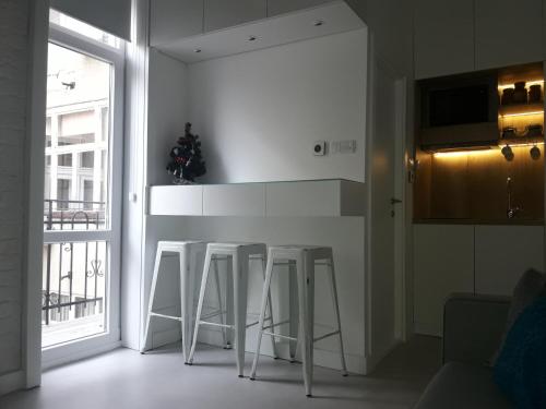 a kitchen with a counter and stools in a room at Momo Apartment in Belgrade