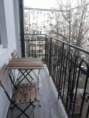 a balcony with a wooden table and a bench at Momo Apartment in Belgrade