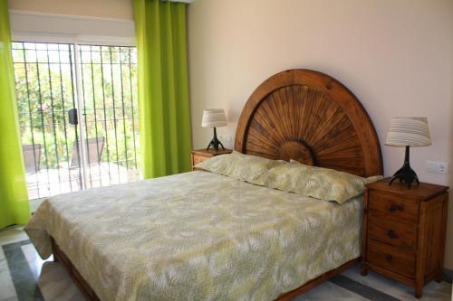 マルベーリャにあるVilla en Senorio de Gonzagaのベッドルーム(大型ベッド1台、大きな窓付)