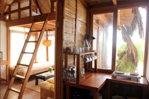a room with a wooden bunk bed with a ladder at Coco Ne in Máncora