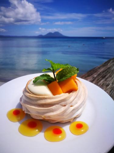 a dessert on a plate on a table near the ocean at Rapopo Plantation Resort in Kokopo