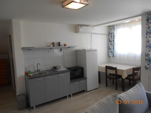 eine kleine Küche mit einem Waschbecken und einem Tisch in der Unterkunft Atocha in Skopje